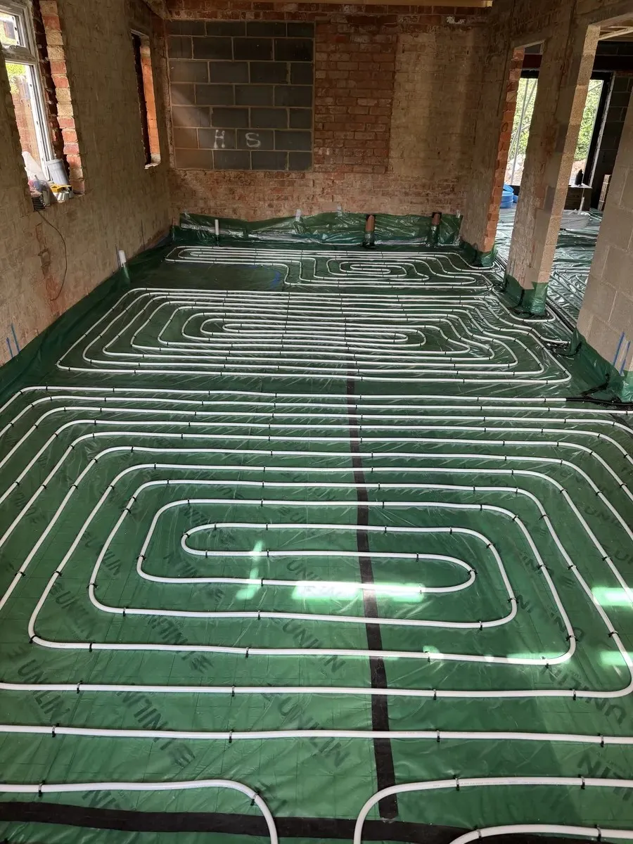 underfloor heating water pipes laid on green tarp